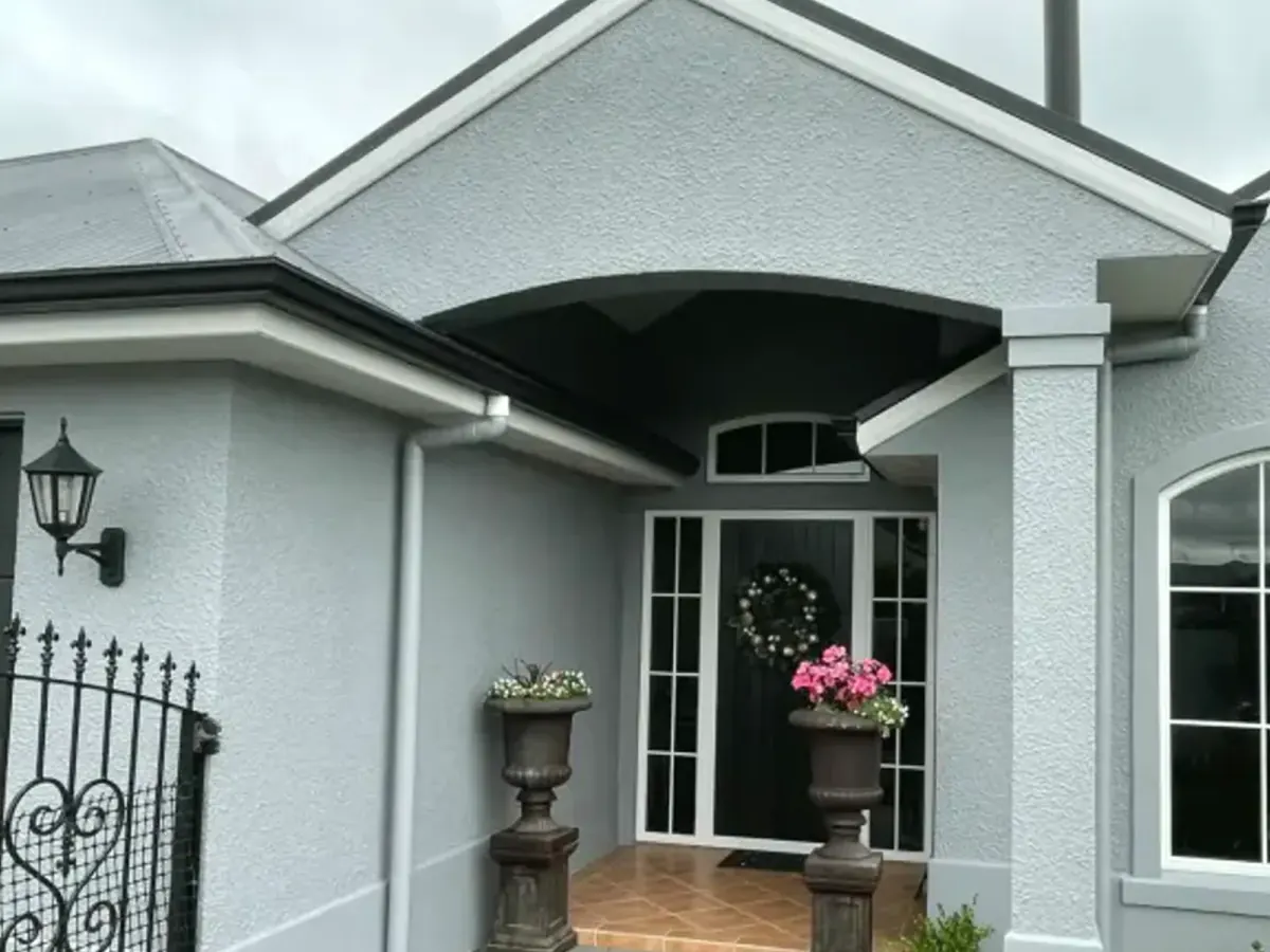 Grey textured exterior entrance with black joinery on an Auckland coastal-style home, Tomar Contracting Auckland